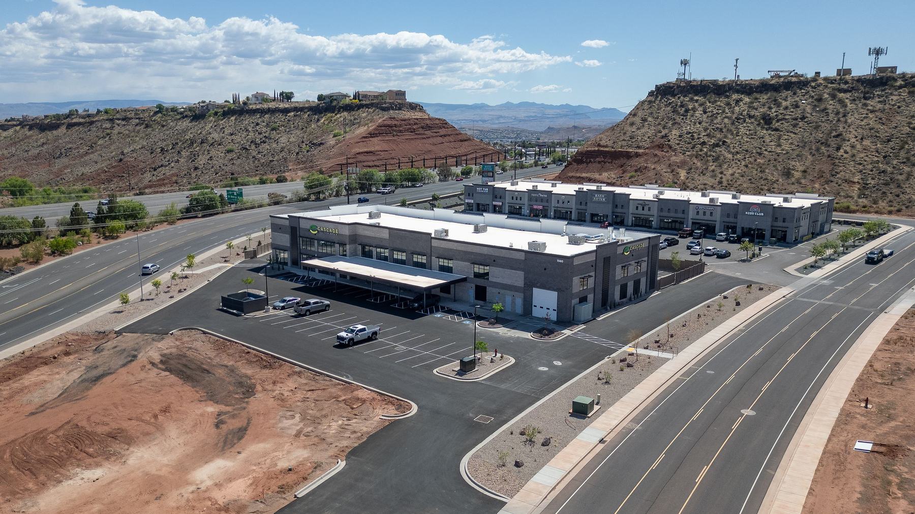 Aerial view of a collision repair center below red rock cliffs