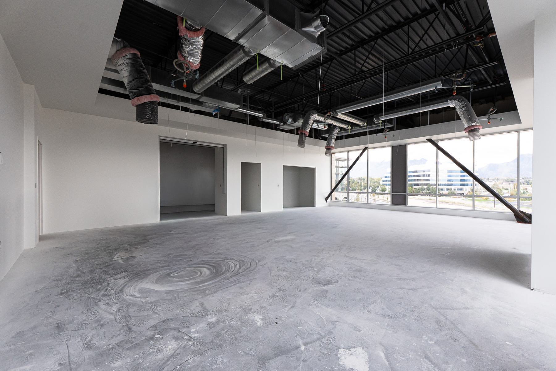 Open office suite with exposed ductwork and a window wall