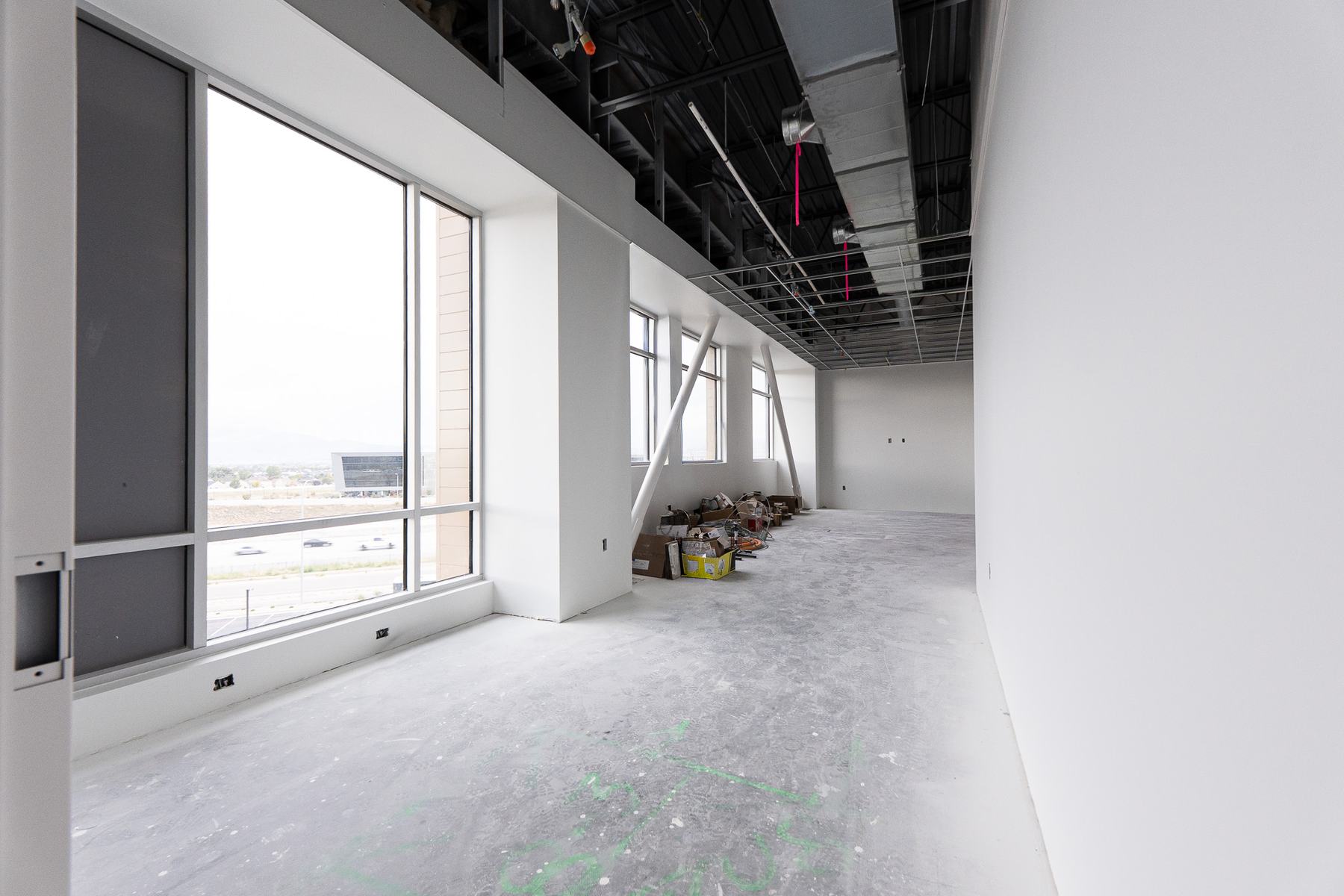 Long office space with tall windows and angled steel braces