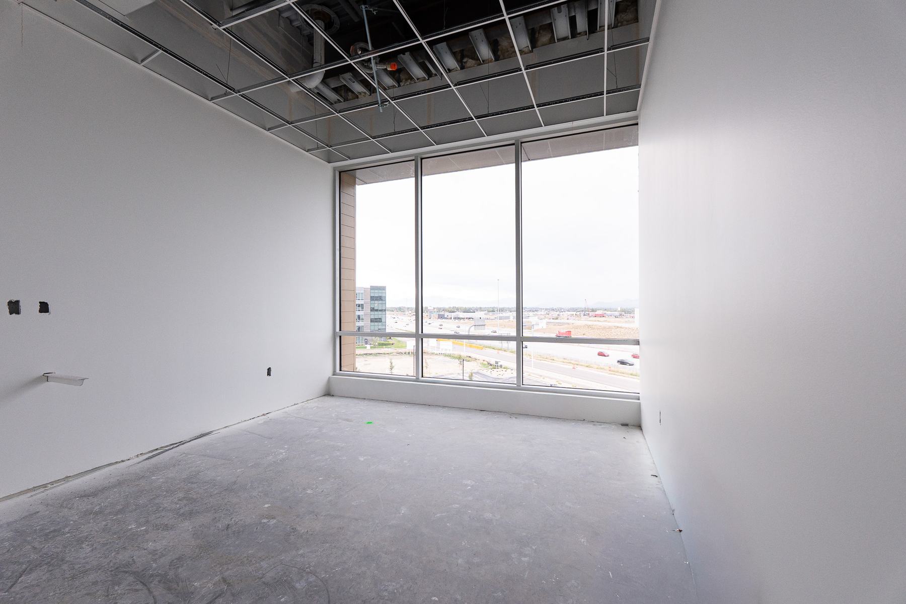Private office with a floor-to-ceiling window over the freeway