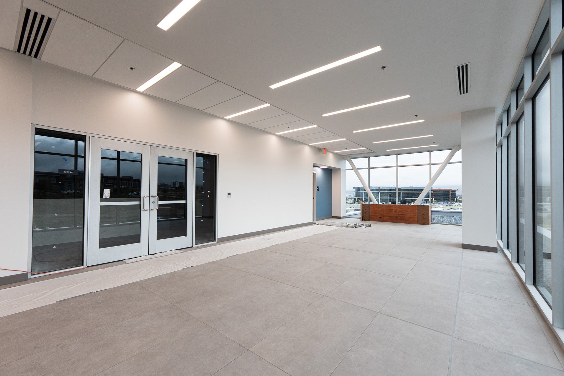 Upper-floor lobby with glass suite entry doors