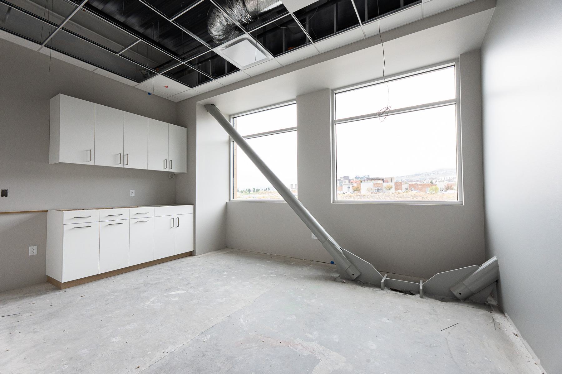 Room with cabinets and an angled steel brace by the windows